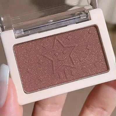 Makeup compact with a brown eyeshadow and a star-shaped logo.